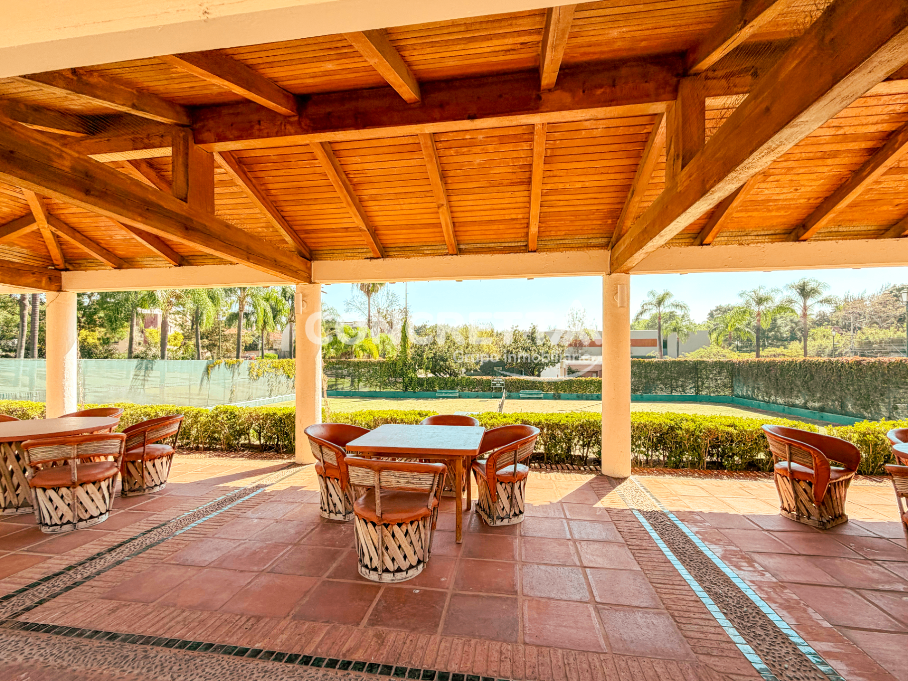 Palapa con área de descanso y vista a canchas