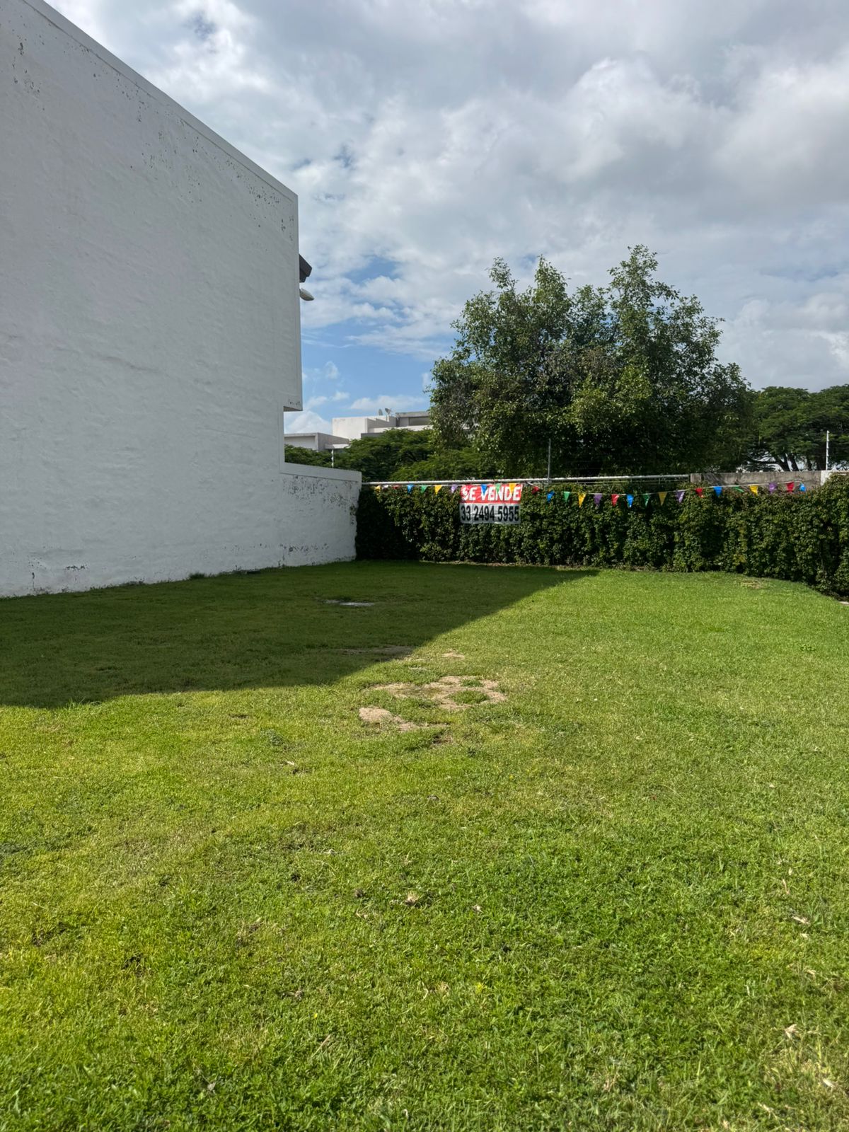 Frente del lote con letrero de venta