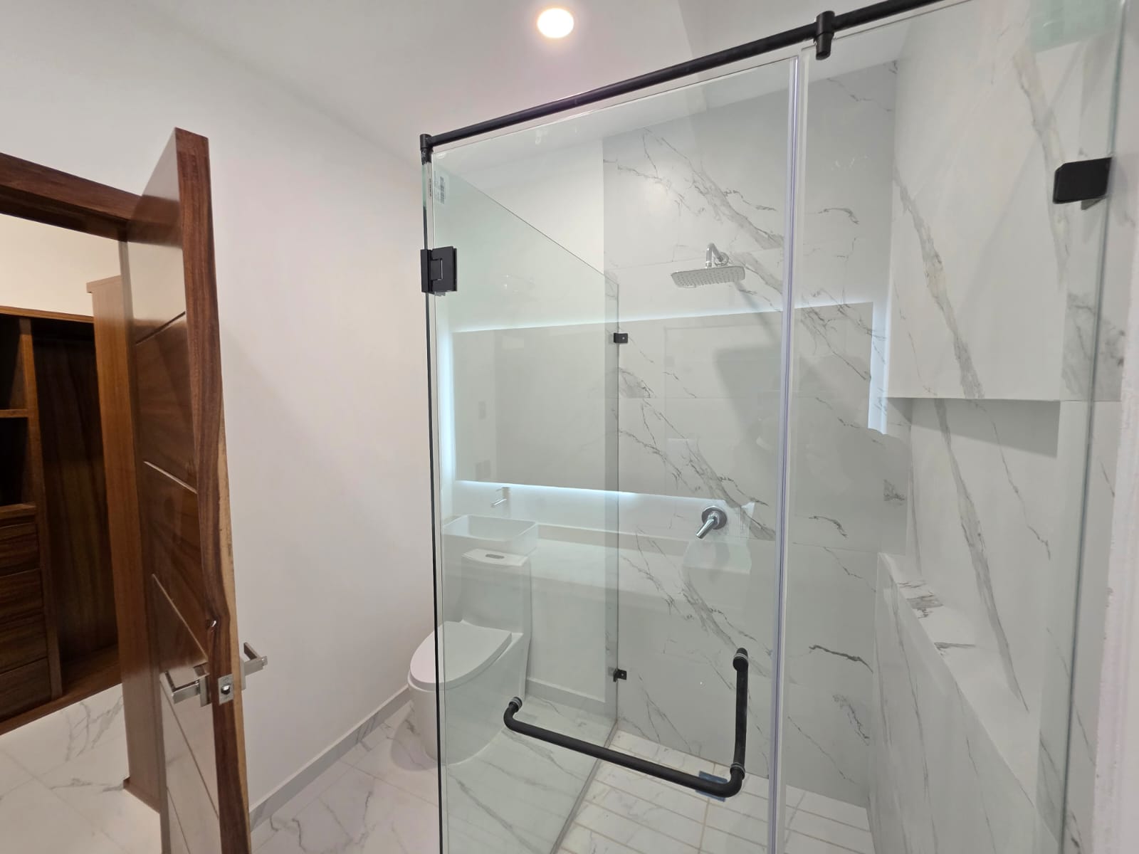 Baño con mármol y cancel negro